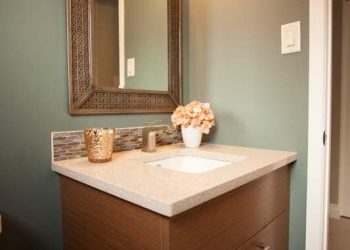 Custom powder room cabinet with quartz top, glass tile backsplash