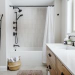 wide angle of bathroom showing towel rack shower and ash vanity with quartz countertop