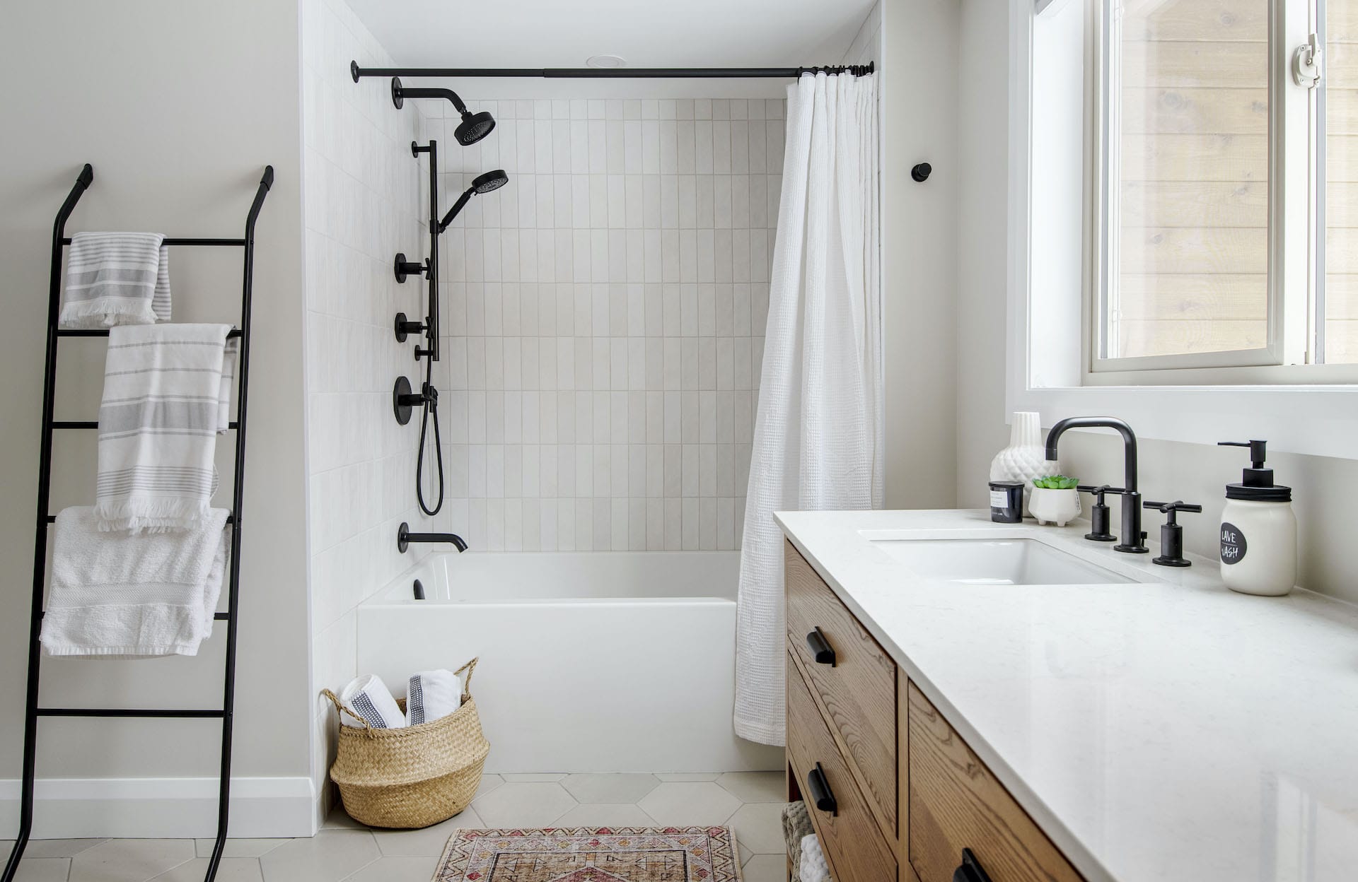 wide angle of bathroom showing towel rack shower and ash vanity with quartz countertop