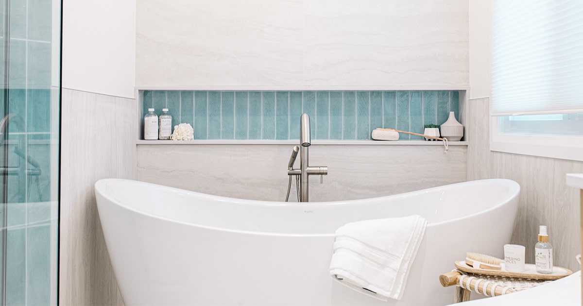 White bathtub in inset space with built-in shelving.