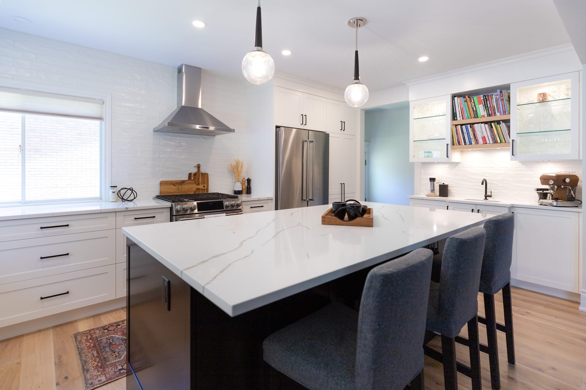 overview of large kitchen with stone-topped island and stainless-steel fridge and stove